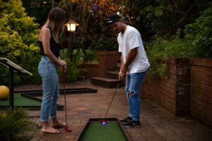 Couple playing mini golf