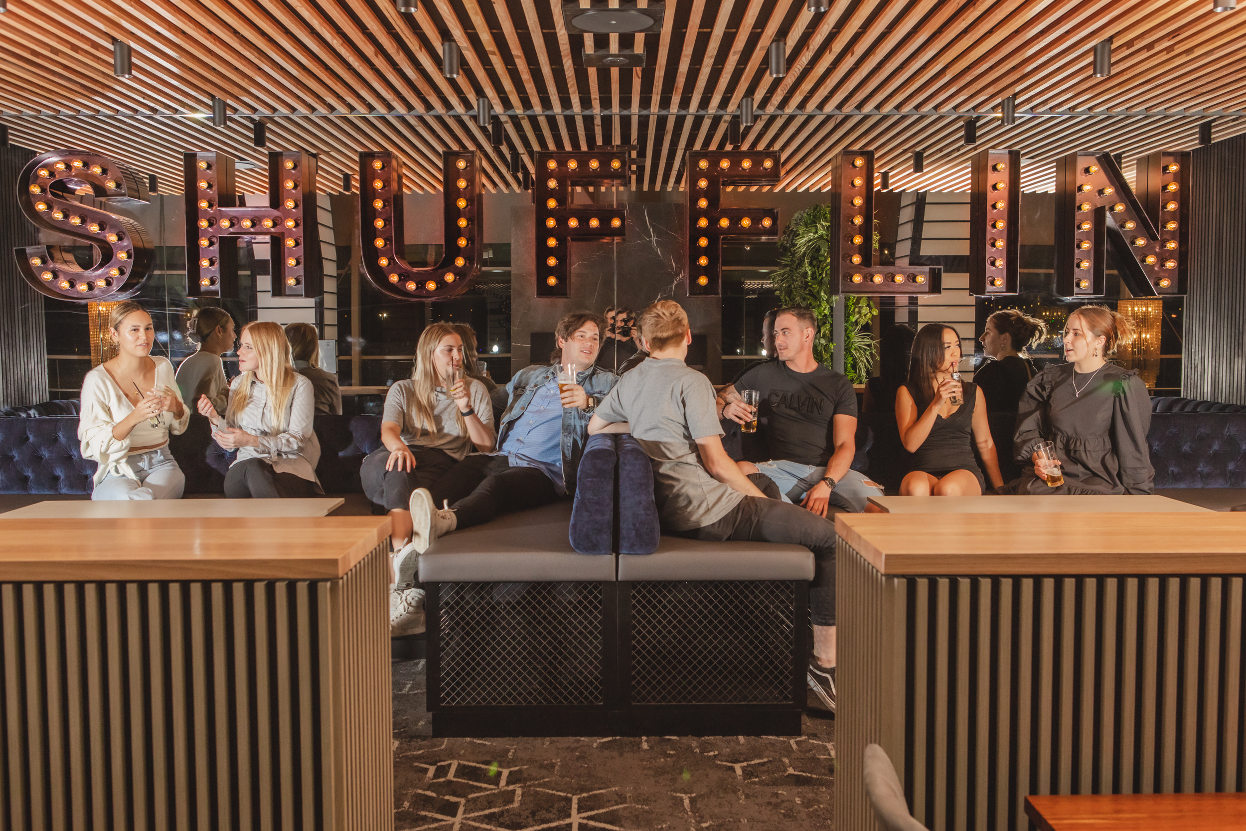 People sitting in front of Shufflin sign