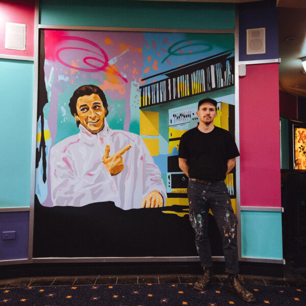 Man standing infront of mural
