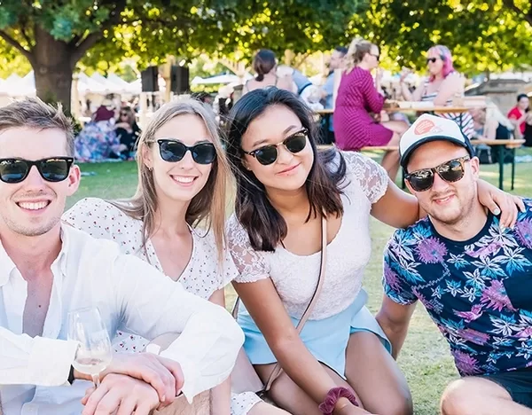 Four people sitting down and drinking wine