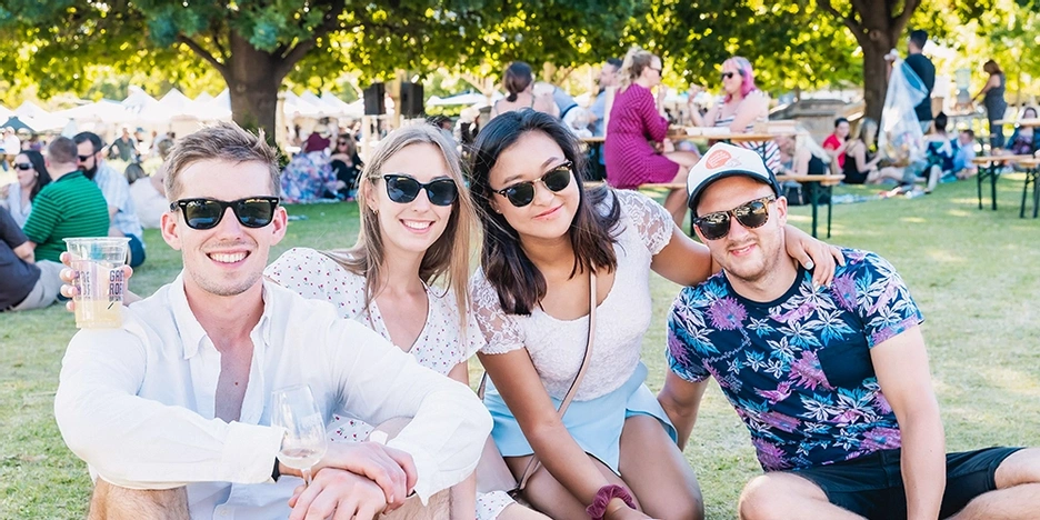 Four people sitting down and drinking wine